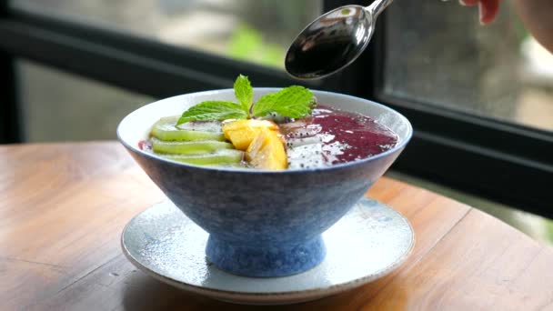 Comer mano de la mujer vegano Smoothie Bowl con frutas frescas, desayuno saludable — Vídeos de Stock