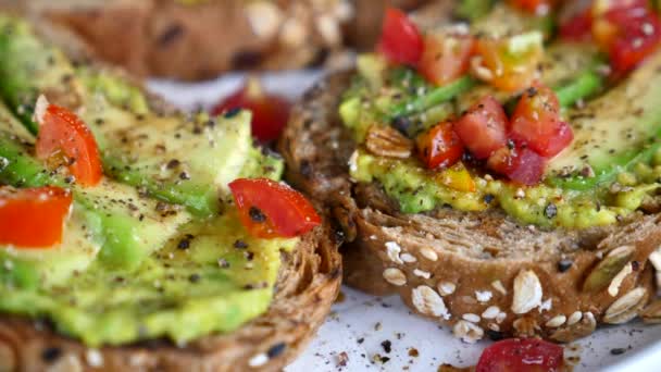 Freshly Avocado Toast with Tomatoes and Black Pepper on Plate — Stock video