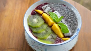 Vejetaryen Gıda Smoothie Kasesi Kiwi, Mango, Ejderha Meyvesi ve Chia tohumlarıyla dolu.