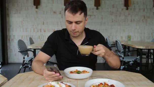 Man met smartphone in de hand en pizza 's in restaurant Drinken Koffie in Cafe — Stockvideo