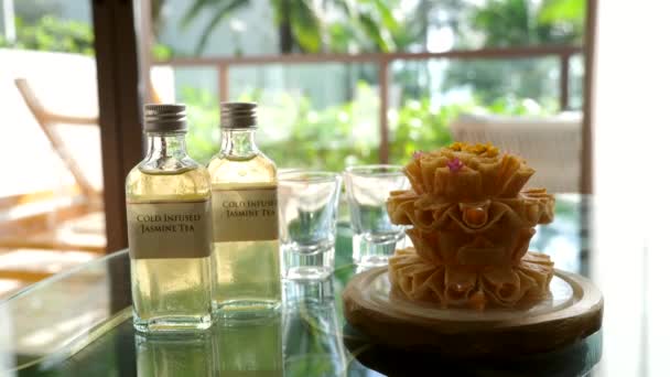 Deux bouteilles en verre avec thé Jasmine infusé à froid debout sur la table avec des lunettes — Video