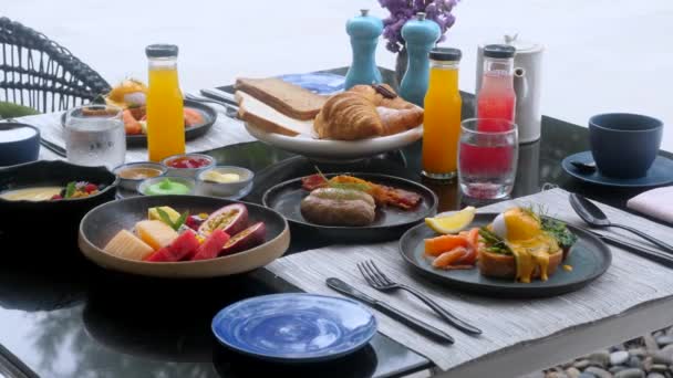 Desayuno en el hotel con huevos recién hechos, salmón, fruta y zumos recién hechos — Vídeos de Stock
