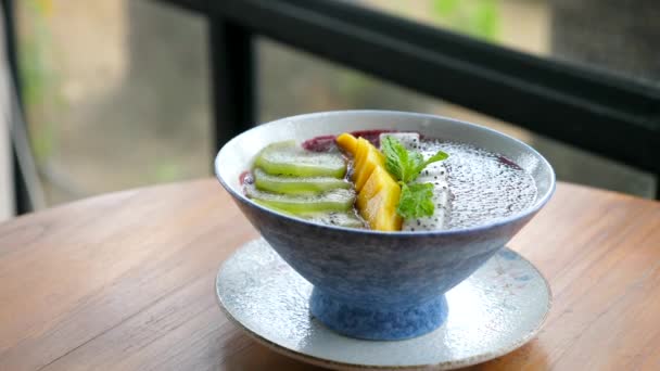 Acai Bowl s tropickým ovocem a semenem Chia v Cafe. Zdravá Veganská snídaně — Stock video
