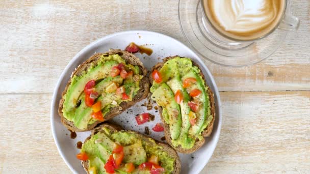 Friska frukost i Cafe - Ovanifrån av färska avokado rostat bröd med tomat — Stockvideo