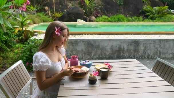 Concepto de dieta, nutrición adecuada. Mujer joven comiendo saludable Smoothie Bowl — Vídeo de stock