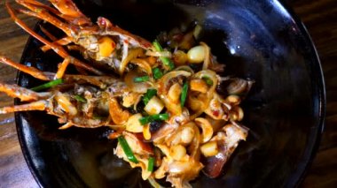 Manzara: Man Hand Take by Fork Black Plate 'den taze kızarmış ıstakoz.