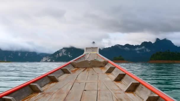 Holzboot segelt auf dem morgendlichen blauen See mit Kalksteinbergen im Nebel — Stockvideo