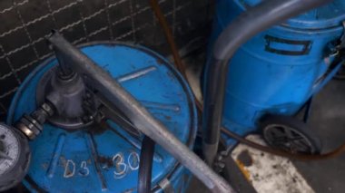 Araba Servisi Garajında hortumları dolduran Yağ Gövdesi. Motor yağı için Mavi Fıçı