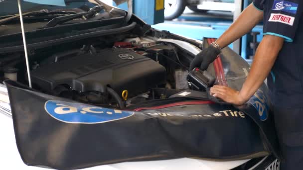 Inginerul verifică nivelul de încărcare a bateriei auto cu multimetru la stația de service auto — Videoclip de stoc