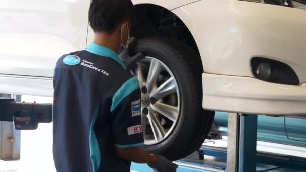 Auto Service Station Specialist Screws Bolts to Wheel on Car Suspended on Lift — Stock Video