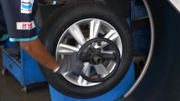 Специалист по автосервису демонтирует новую шину из балансировщика колес — стоковое видео