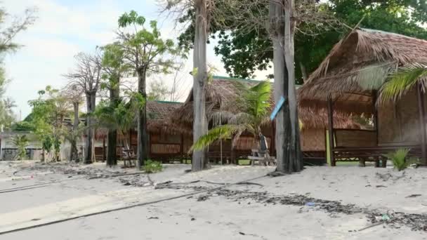 Pequeñas casas de bungalows, tejado de paja en la playa con palmeras tropicales en la isla — Vídeos de Stock