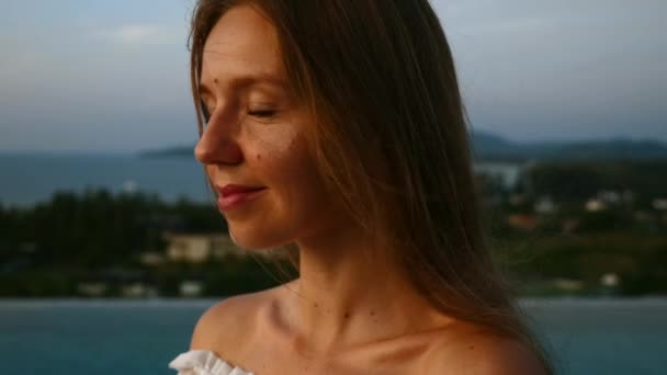 Close-up van vrouw gezicht kijken naar zonsondergang, ontspannen en diep ademhalen op het dak — Stockvideo