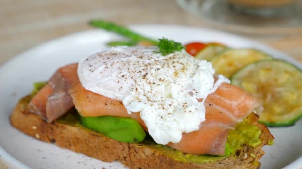 Färsk avokado toast med rökt lax och pocherade ägg, låg kolhydrat och Keto — Stockvideo