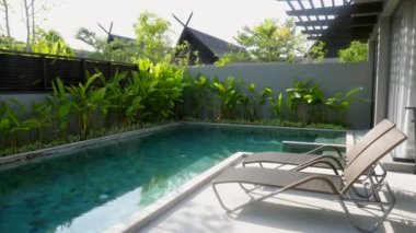 Yüzme Havuzu ve Tropikal Yeşiller Yakınındaki İki Güneşli Yataklı Tatil Köşkü