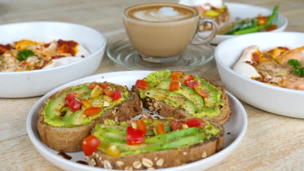 Zdrowe jedzenie w kawiarni - Vegan Toast z awokado i pomidorów, świeże owoce morza Pizze — Wideo stockowe