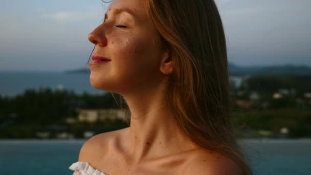 Close-up van vrouw gezicht kijken naar zonsondergang, ontspannen en diep ademhalen op het dak — Stockvideo