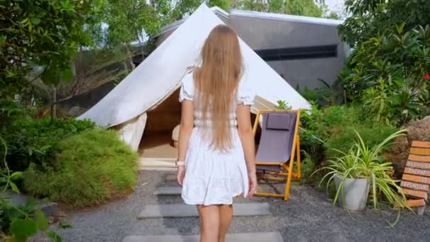 Primer plano Vista trasera de la mujer joven en vestido blanco caminando dentro de la tienda de campaña Glamping — Vídeo de stock