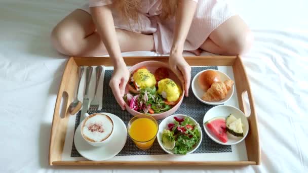 Frühstück im Bett mit einer Tasse Kaffee, Salat, frischem Obst und Ei Benedict — Stockvideo