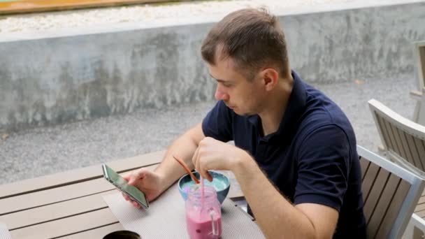 Young Man Read Social Media News in Smartphone in Vegan, Wegetariańskie jedzenie Cafe — Wideo stockowe