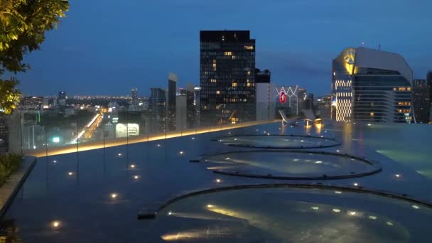 Вид на небо Роскошный бассейн в вечернее время с небоскребами и дороги на заднем плане — стоковое видео