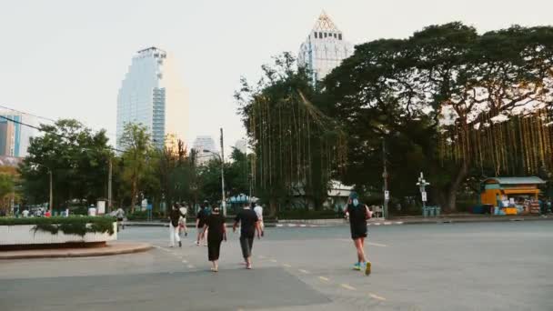 Група людей біжить і біжить надвір у громадському парку ввечері — стокове відео