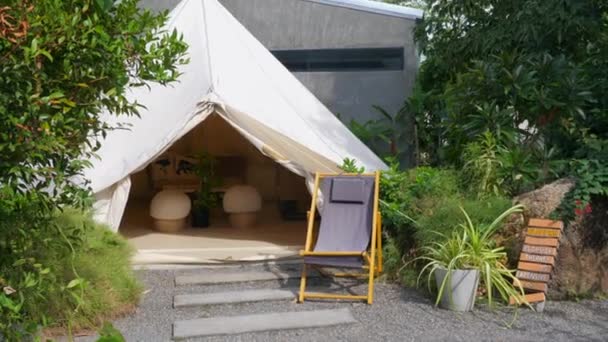 Brede glamping tent met comfortabel modern interieur, open entree, lounge stoel — Stockvideo