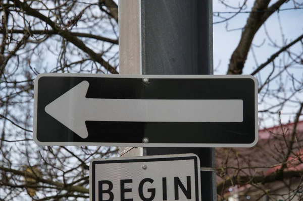 A one-way sign beside the road.  North Vancouver BC Canada