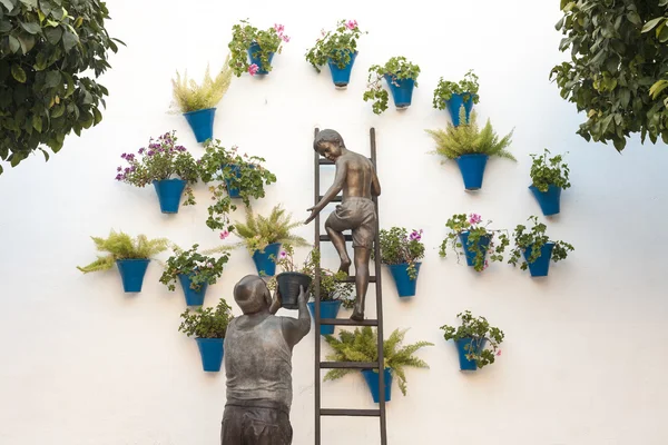 Granny and his grandson placing flowerpots on the wall, Cordoba, — Stock Photo, Image