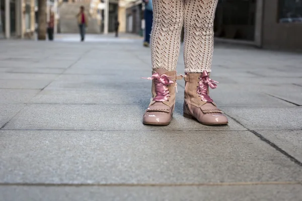 Маленькая девочка в розовых сатиновых кружевных сапогах по городу — стоковое фото