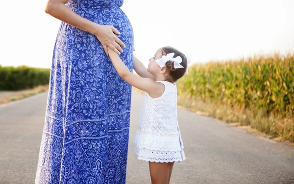 Mãe grávida e sua filha entre campos de milho — Fotografia de Stock