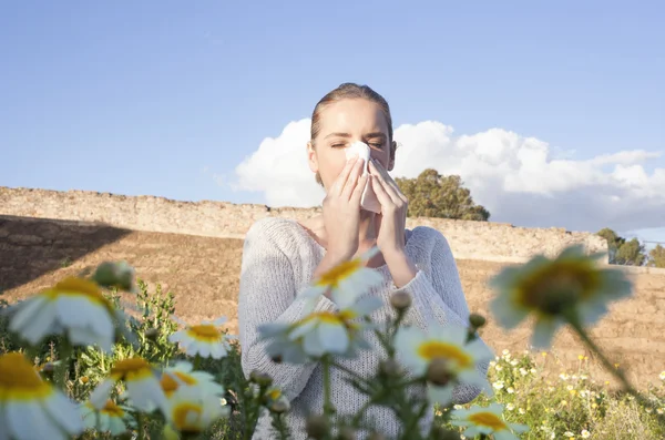 Wanita muda alergi bersin di padang rumput — Stok Foto