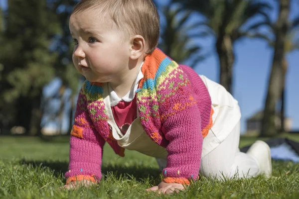 Babymädchen lernt im Rasenpark zu kriechen — Stockfoto