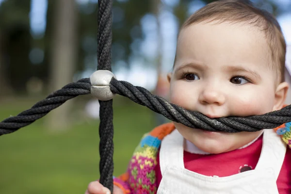 Baby beißt Spielplatzseile — Stockfoto