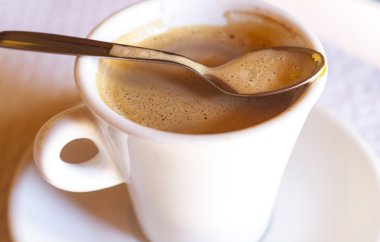 Kenar üzerinde kaşıkla kahve fincanı