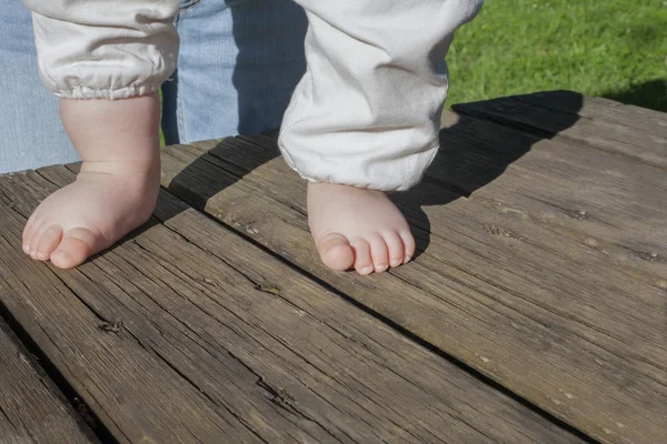 Die nackten Füße eines Babys bei seinen ersten Schritten — Stockfoto