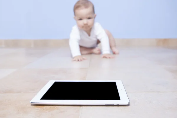 Baby boy crawling to a tablet — Stock Photo, Image