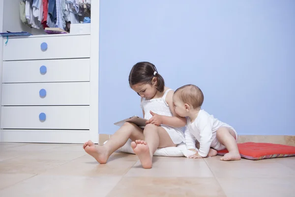Baby boy att upptäcka hennes syster för tablet pc — Stockfoto