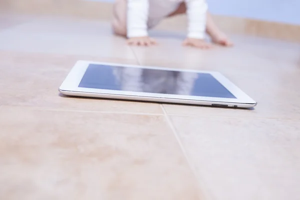 Baby boy crawling to a tablet — Stock Photo, Image