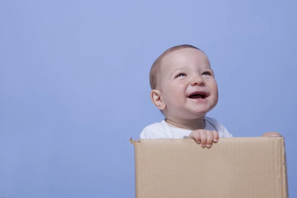 Bebé niño jugando en caja de cartón Imagen de stock