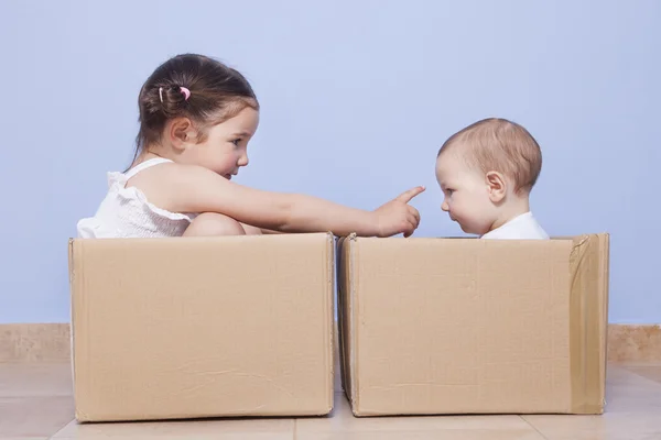 Petits frères jouant avec des boîtes en carton — Photo