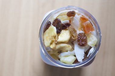 Ahşap yüzey üzerine karışık kuru meyve ile plastik kavanoz