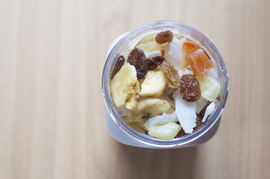 Ahşap yüzey üzerine karışık kuru meyve ile plastik kavanoz