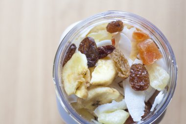 Ahşap yüzey üzerine karışık kuru meyve ile plastik kavanoz