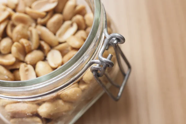 Open canning jar with fried salty peanuts. Overhead view — Stock Photo, Image