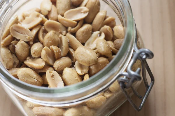 Open canning jar with fried salty peanuts. Overhead view — Stock Photo, Image