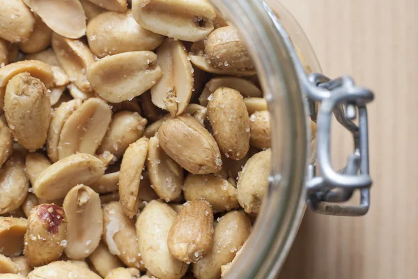 Open canning jar with fried salty peanuts. Overhead view — Stock Photo, Image