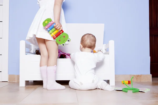 Pojke leker med sin syster på leksaker room — Stockfoto