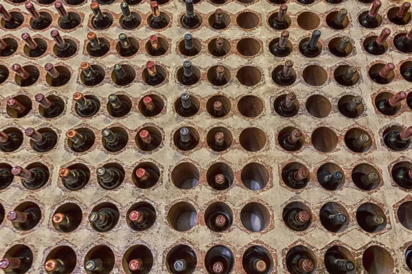 Bodega botellas filas dispuestas en agujeros de pared de ladrillo — Foto de Stock