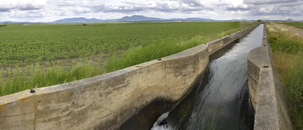 Bevattning canal flödar över de bördiga ängarna av hög Guadiana — Stockfoto